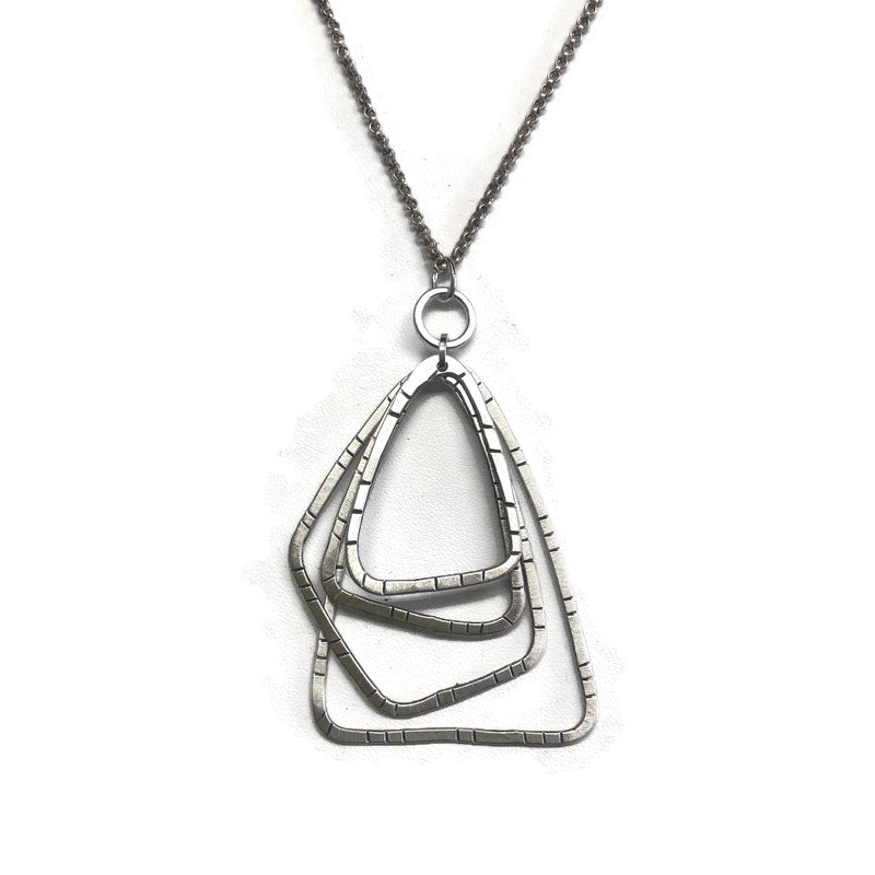 Silver necklace with a geometric pendant on a white background