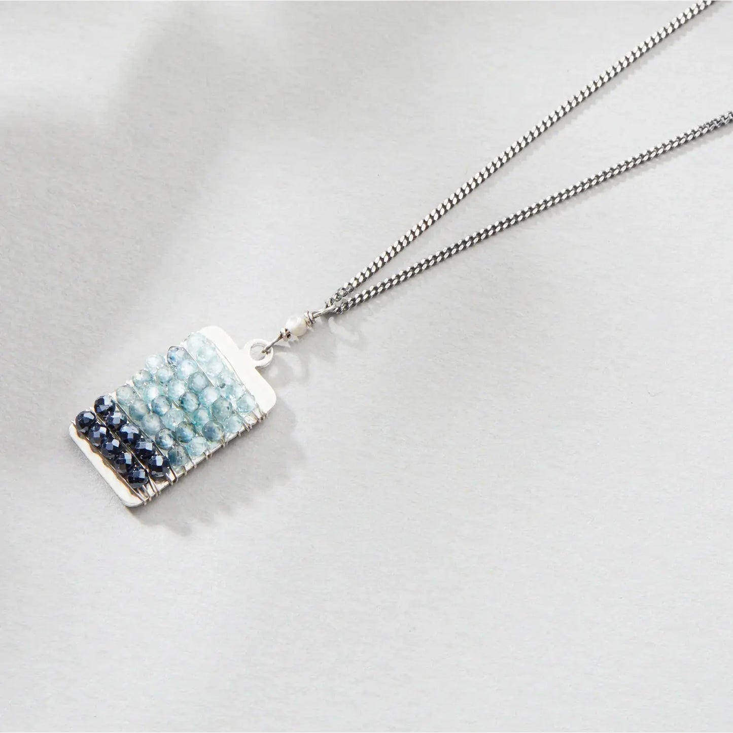 Necklace with a rectangular pendant featuring blue and silver stones