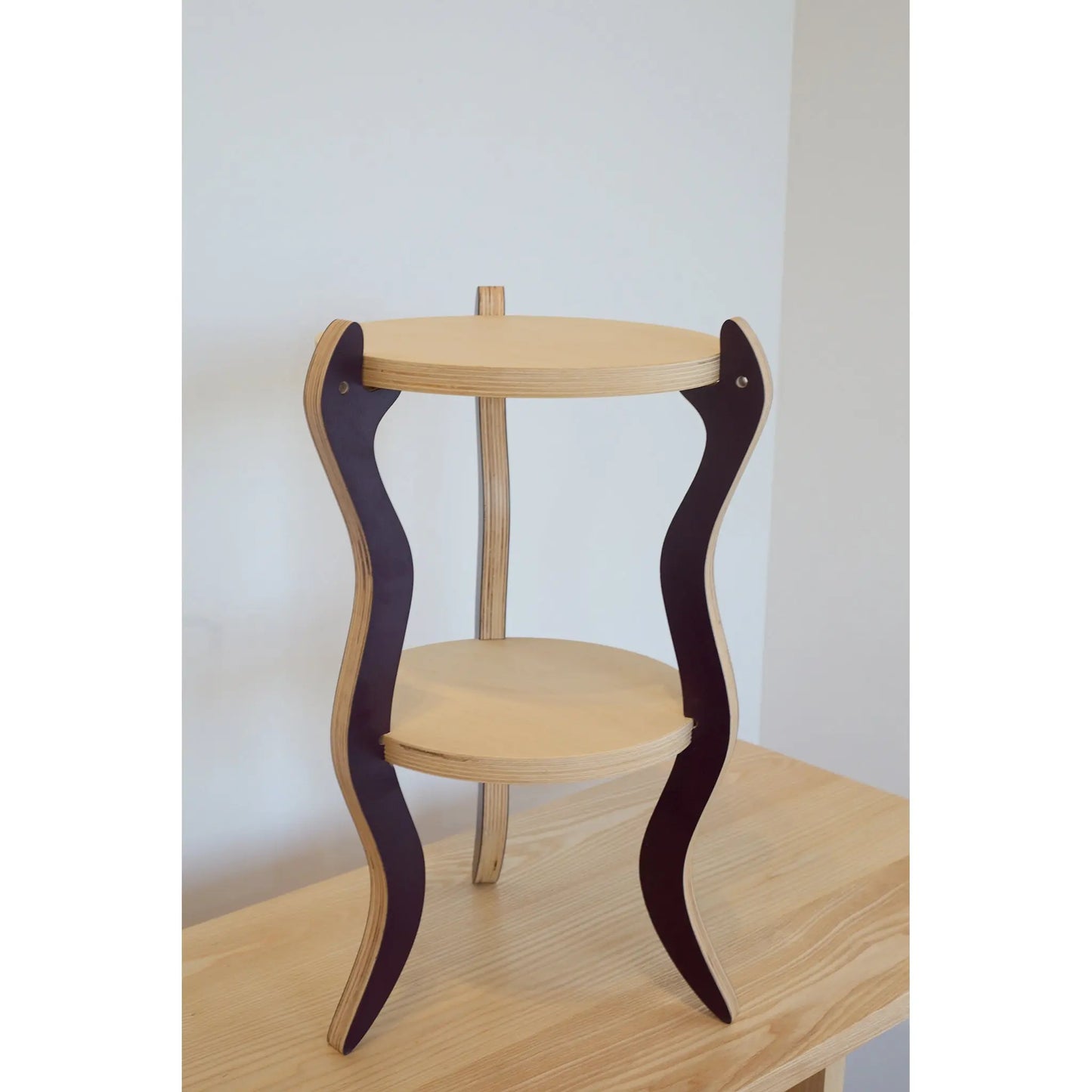 Wooden table with snake legs on a plain background