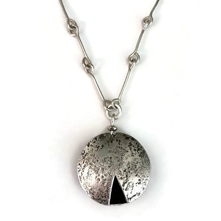 Sterling silver necklace with a round pendant featuring a black triangle 