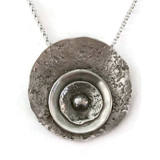Sterling silver necklace with a textured round pendant 