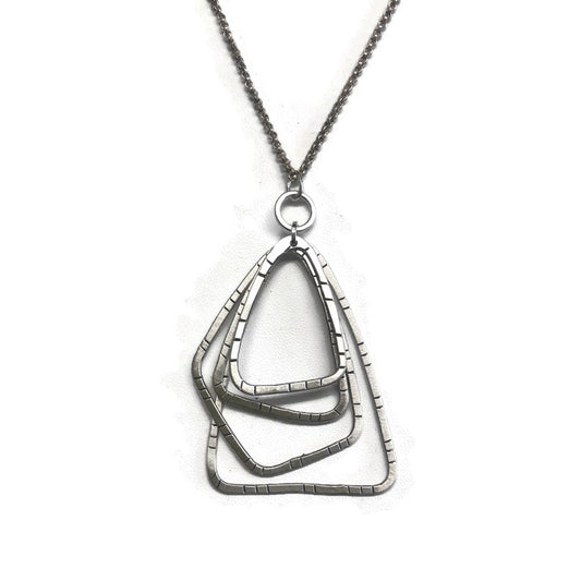 Silver necklace with a geometric pendant on a white background