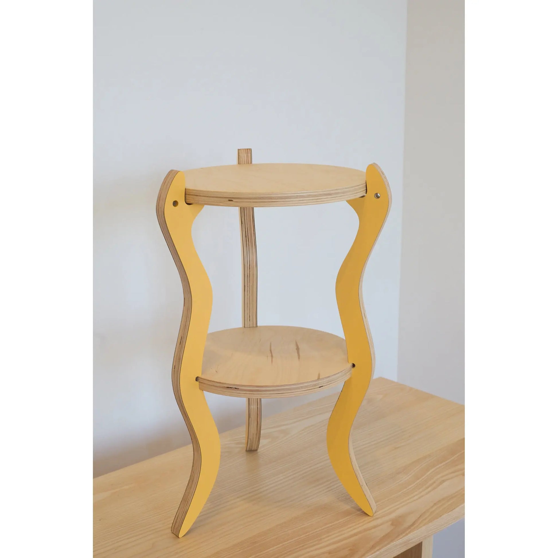 Wooden table with yellow snake legs on a plain background
