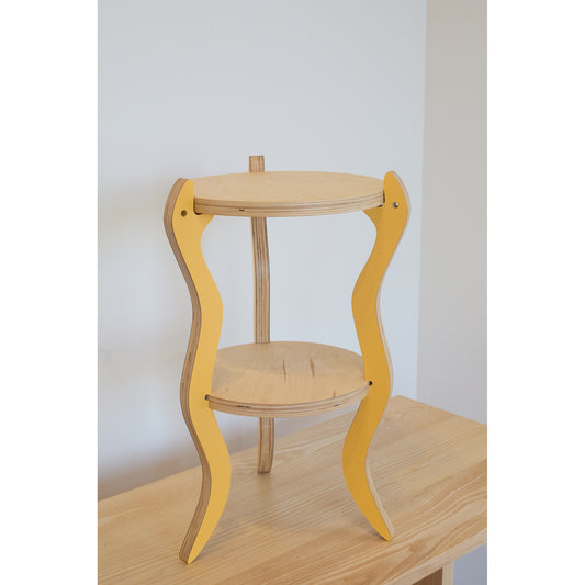 Wooden table with yellow snake legs on a plain background