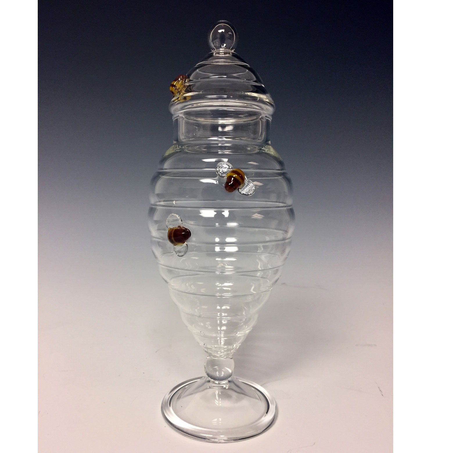 https://www.sweetheartgallery.com/cdn/shop/products/Sage-Studios-Glass-Beehive-Apothecary-Jar-Bees-Line-Functional-Art-Glass-Covered-Vessels.jpg?v=1555862242