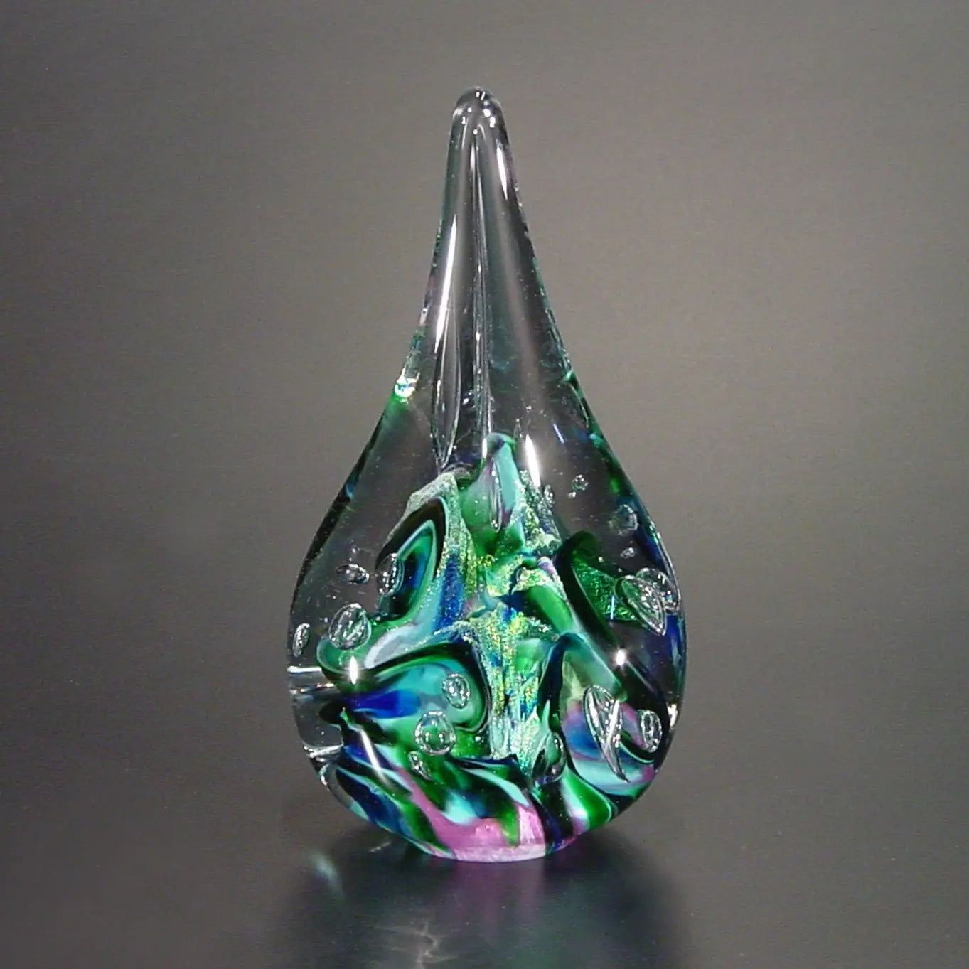 The Glass Forge Twisted Flame Paperweight Shown In Purple Turquoise And Teal Artistic Functional Artisan Handblown Art Glass Paperweights